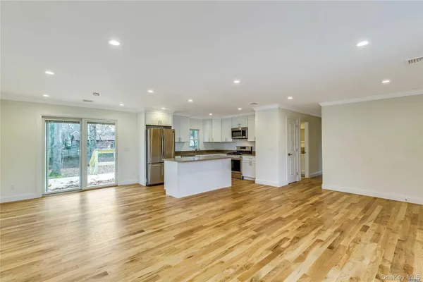 a large kitchen with stainless steel appliances granite countertop a large counter top and a wooden floors