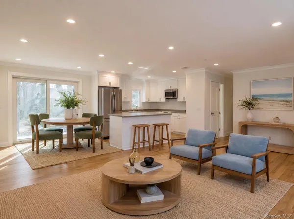 a living room with furniture and a dining table with kitchen view