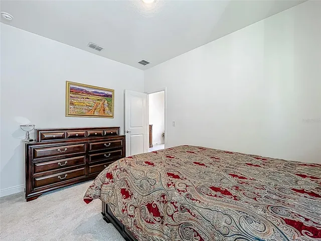 a bedroom with a large bed a flat tv screen and dresser