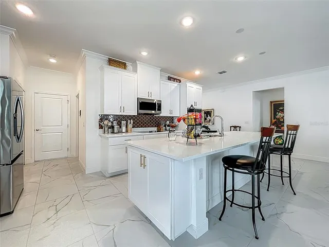 a kitchen with stainless steel appliances kitchen island granite countertop a sink and cabinets