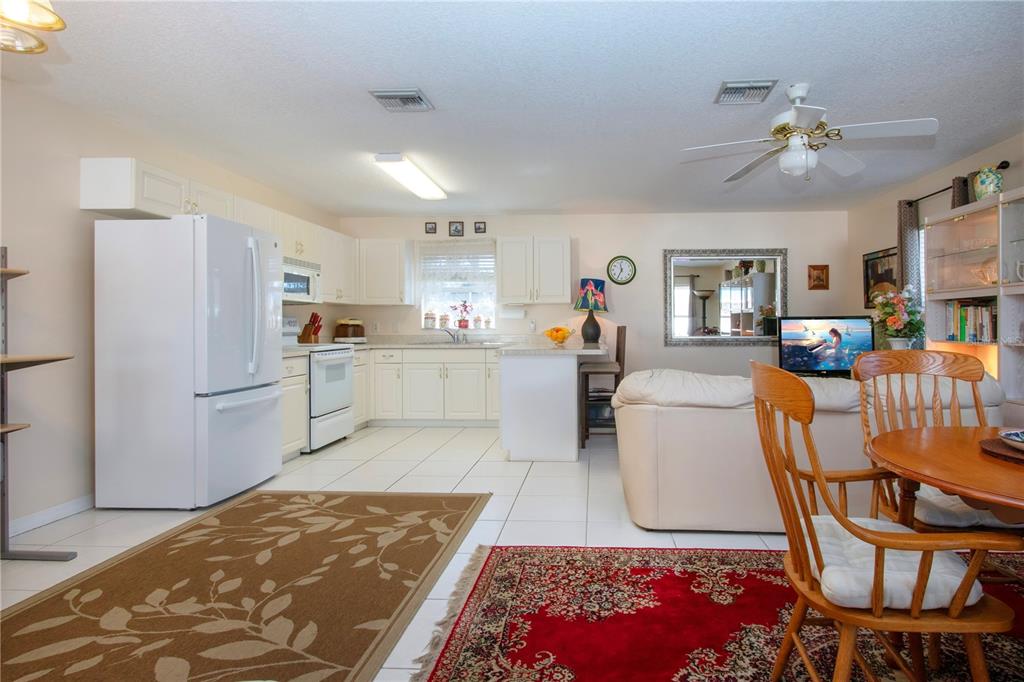 4010 North Lockwood Ridge Road Sarasota, FL 34235 - Photo 15 of 64 a kitchen with stainless steel appliances granite countertop a refrigerator a stove a sink dishwasher with a dining table and chairs with wooden floor