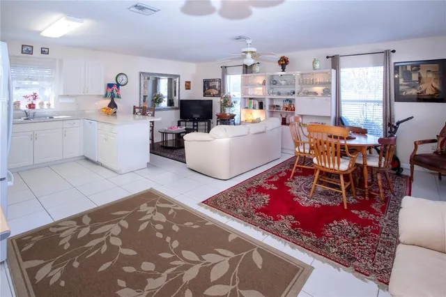 a living room with furniture a dining table and large windows
