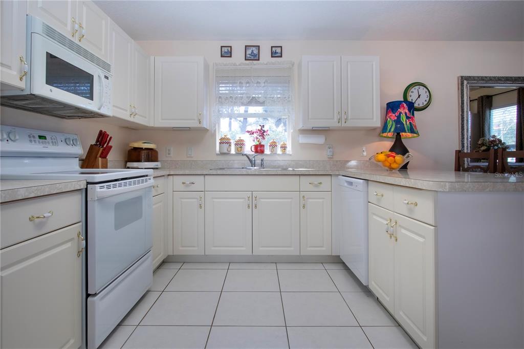 4010 North Lockwood Ridge Road Sarasota, FL 34235 - Photo 24 of 64 a kitchen with white cabinets and white appliances