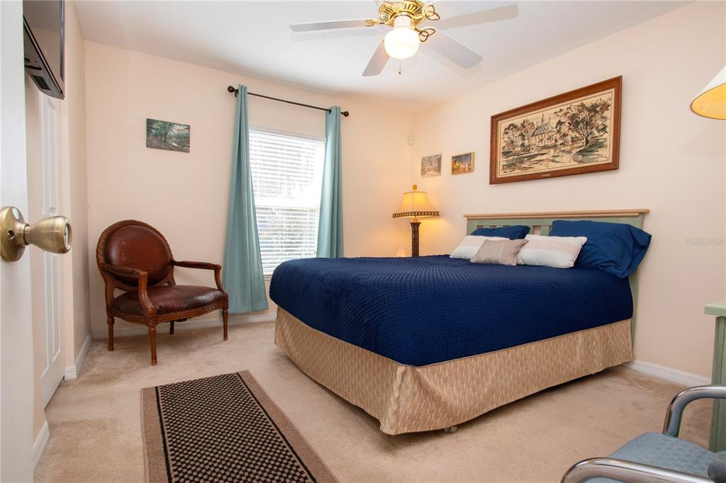 4010 North Lockwood Ridge Road Sarasota, FL 34235 - Photo 37 of 64 a bedroom with a bed a chair and a chandelier