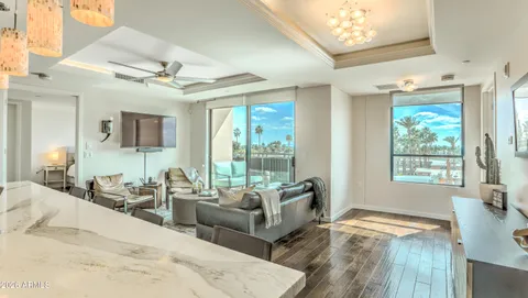 a spacious bedroom with a bed a chandelier and large window