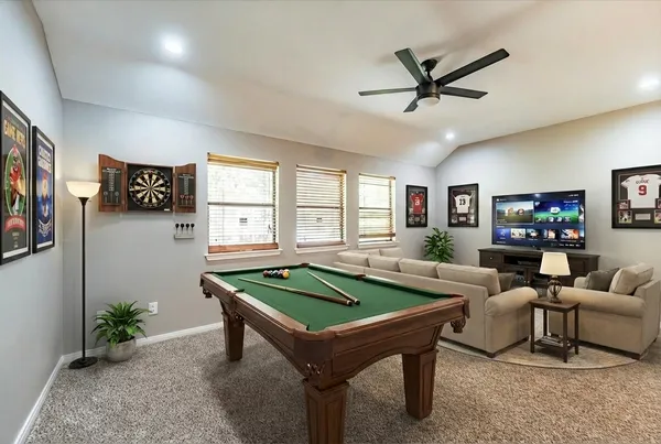 an empty room with ceiling fan and windows