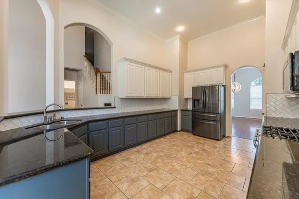 a kitchen with granite countertop a refrigerator and a sink