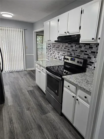 a kitchen with granite countertop a stove and a sink