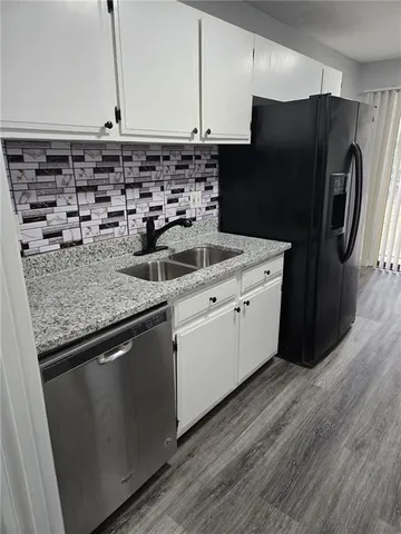 a kitchen with a sink a refrigerator and cabinets