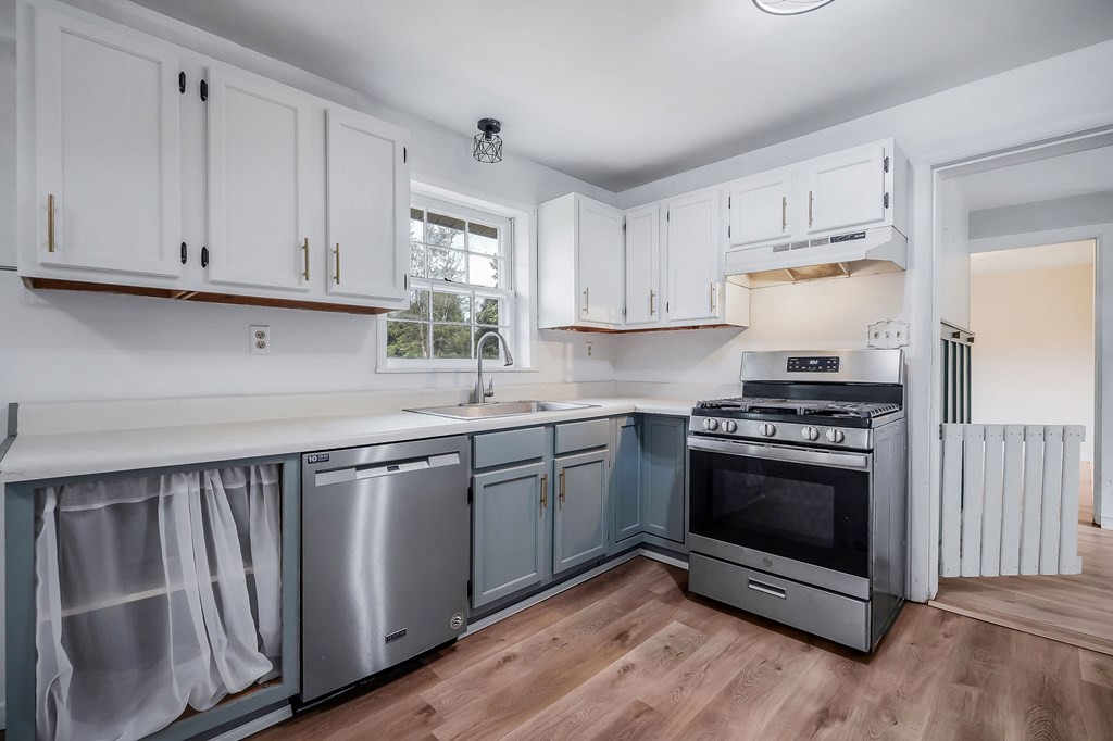 87 Camp Overton Road Rock Island, TN 38581 - Photo 15 of 46 a kitchen with stainless steel appliances granite countertop a stove a sink and a white refrigerator with white cabinets