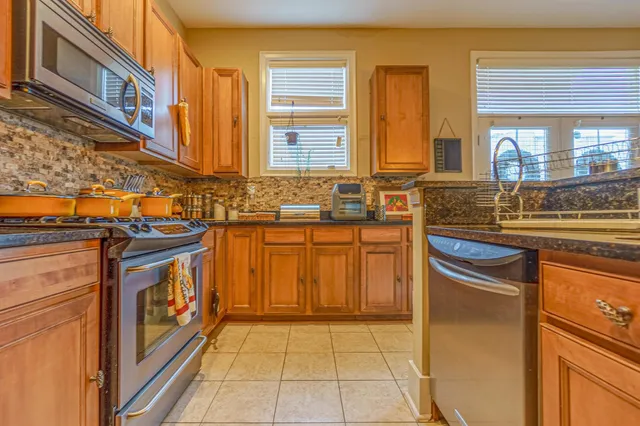 a kitchen with stainless steel appliances granite countertop a stove a sink and a refrigerator