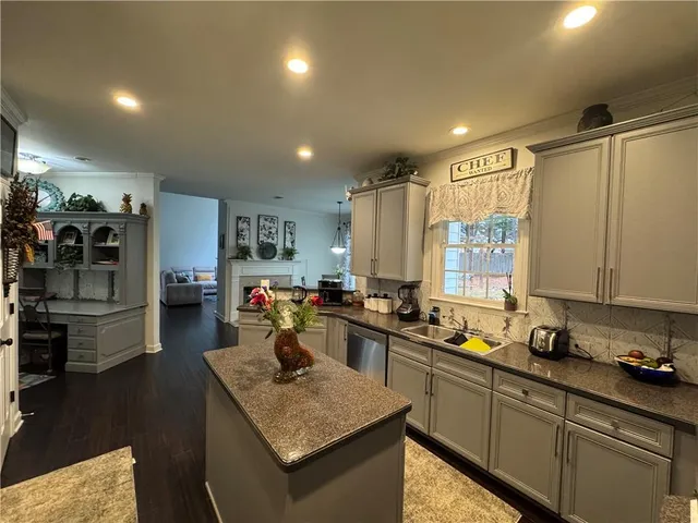 a kitchen that has a lot of cabinets a sink and appliances in it