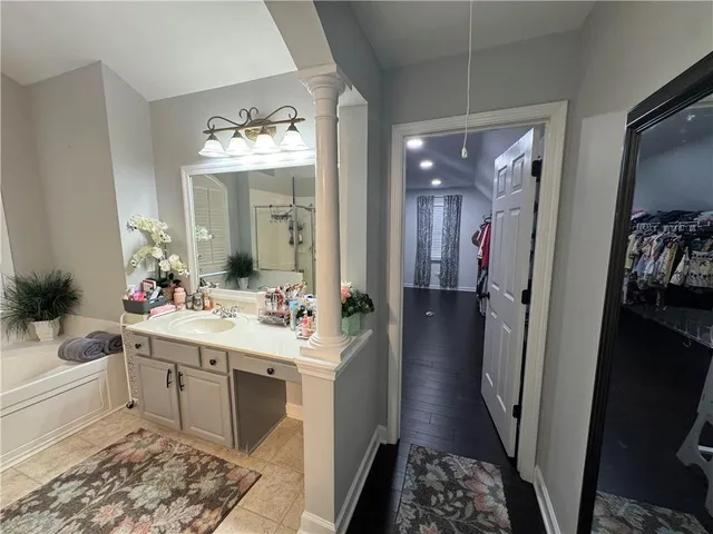 a en suite bathroom with a sink double vanity granite and a mirror
