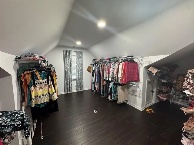 a view of walk in closet with clothes and shoes