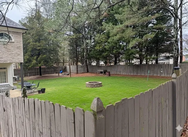 a view of garden with wooden fence