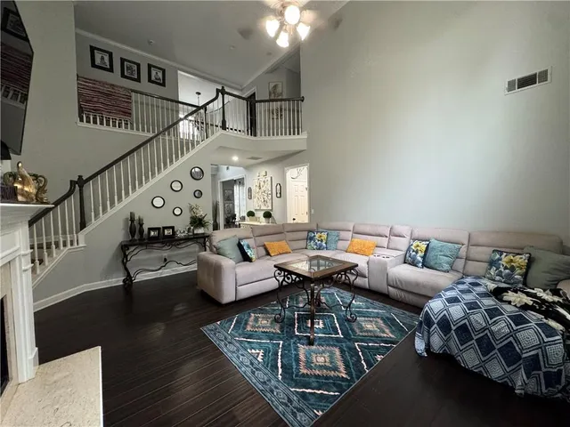 a living room with furniture stairs and a chandelier