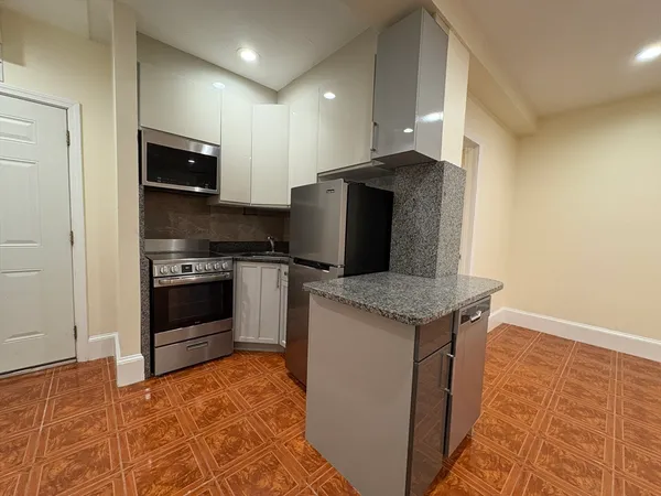 a kitchen with stainless steel appliances granite countertop a stove a refrigerator and a sink