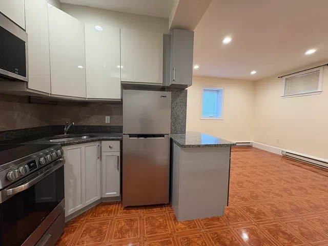 a kitchen with stainless steel appliances granite countertop a refrigerator a stove and a microwave