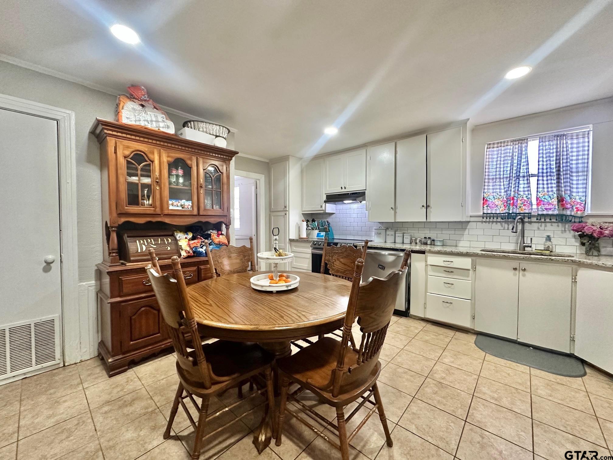 2601 East George Richey Road Longview, TX 75604 - Photo 11 of 26 a kitchen with a dining table cabinets and appliances
