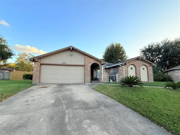 a view of house with a yard and garage
