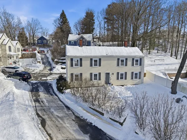 a view of a house with backyard and trees