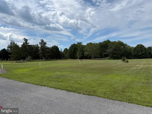 a view of a green field with wooden fence