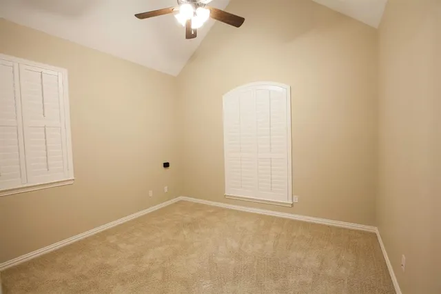 an empty room with chandelier fan