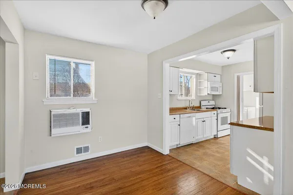 a view of a kitchen with wooden floor and windows