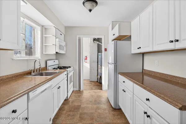 a kitchen with granite countertop a sink stainless steel appliances and cabinets