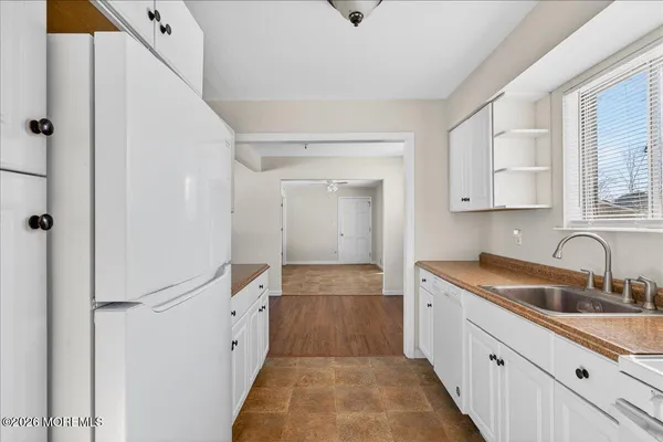 a kitchen with white cabinets and sink