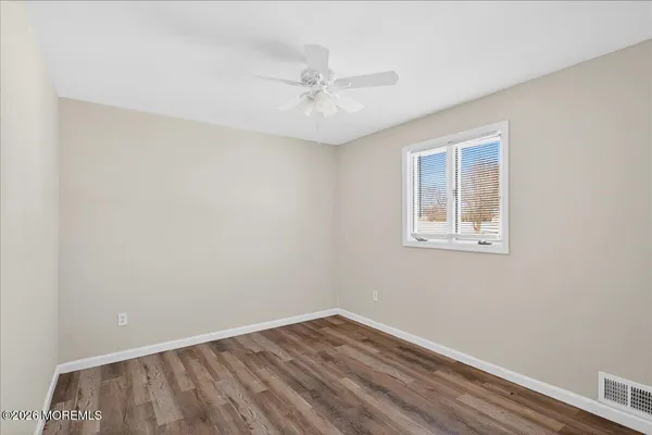 an empty room with a window and a ceiling fan
