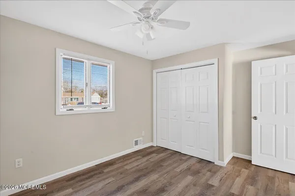 an empty room with a window and a ceiling fan