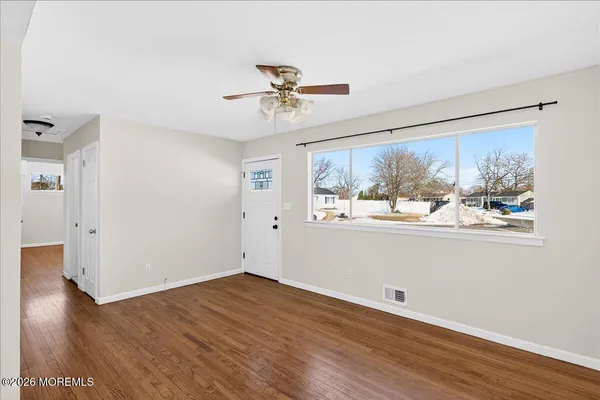 a view of a big room with wooden floor and windows in a room