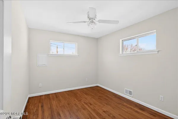 an empty room with a window and wooden floor