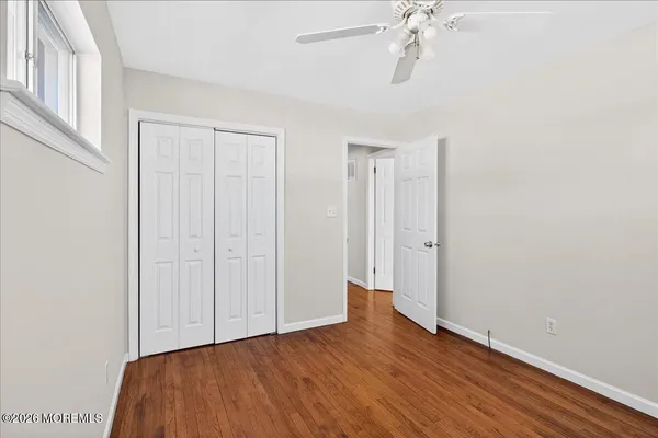 a view of a room with wooden floor and fan