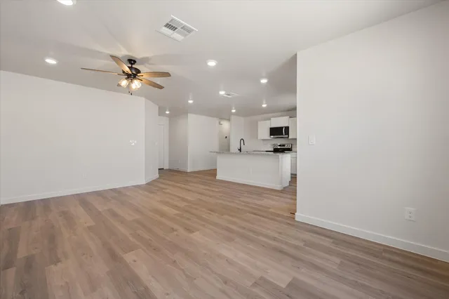 a view of a kitchen with a sink and wooden floor