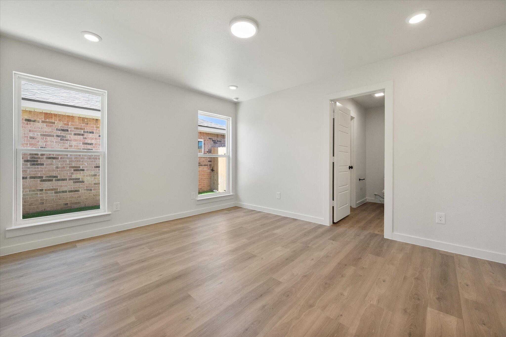 8316 24th Street Lubbock, TX 79407 - Photo 13 of 22 an empty room with wooden floor and windows