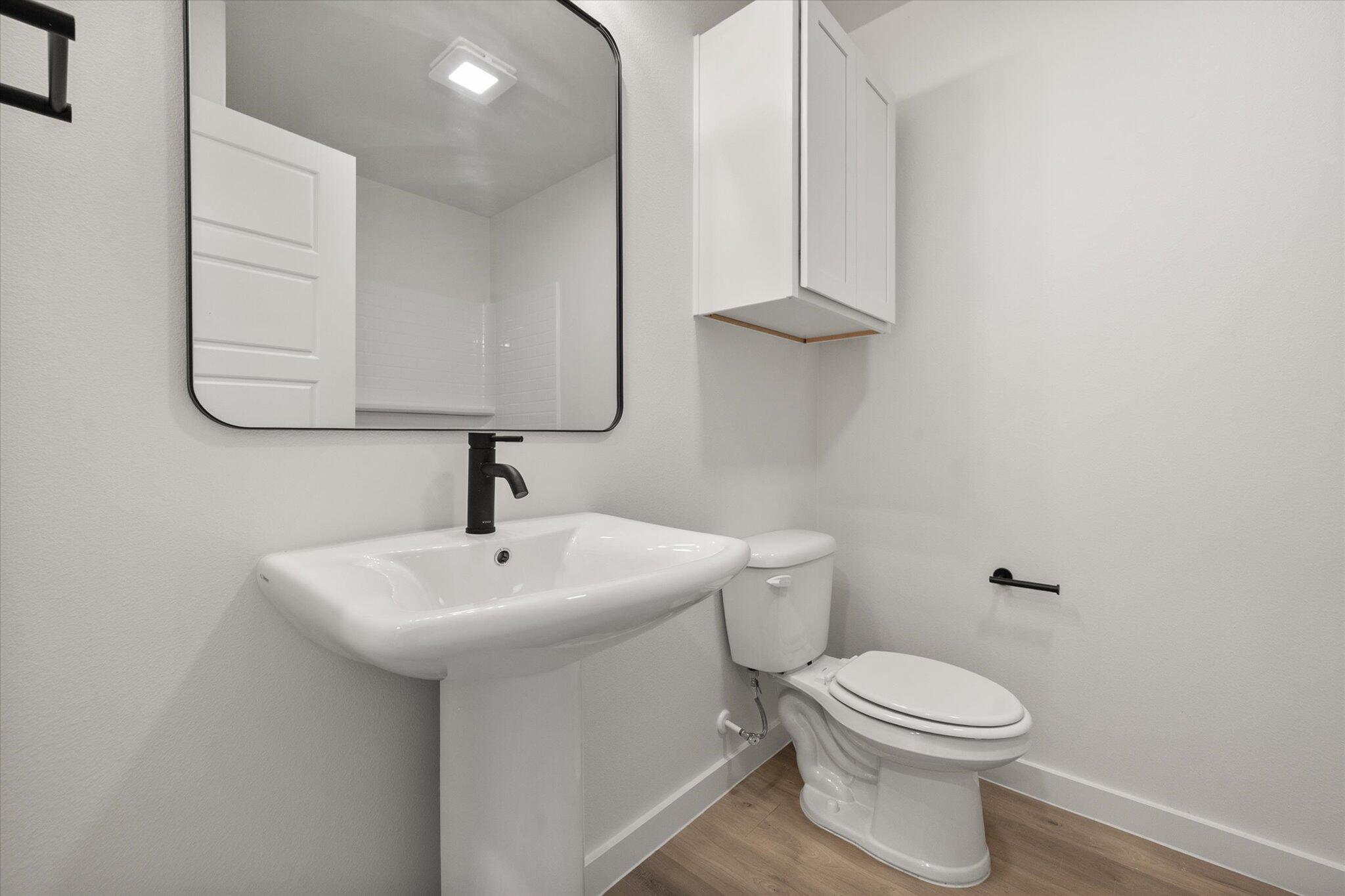 8316 24th Street Lubbock, TX 79407 - Photo 15 of 22 a bathroom with a toilet sink and mirror