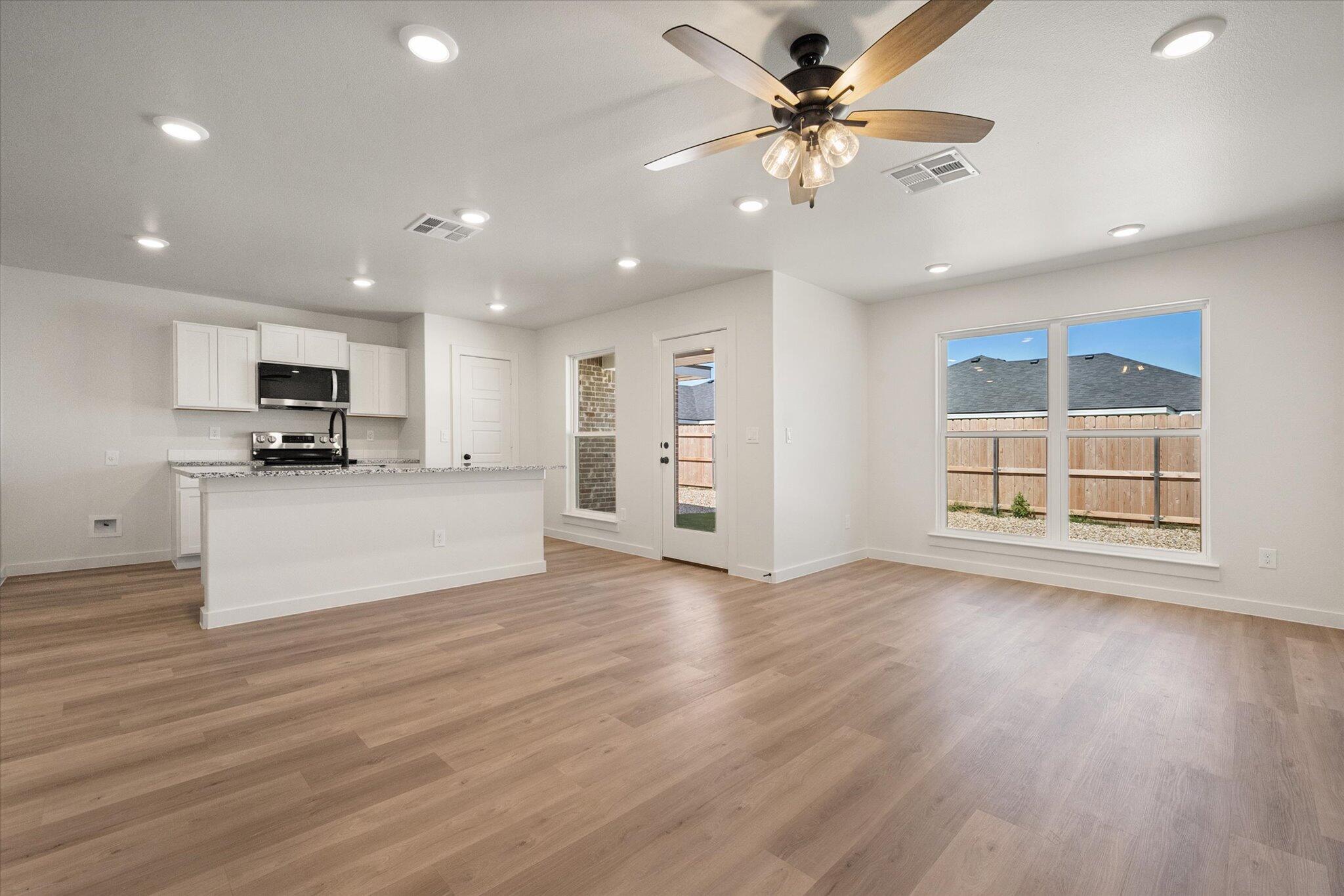 8316 24th Street Lubbock, TX 79407 - Photo 4 of 22 a view of a kitchen with furniture a ceiling fan and wooden floor