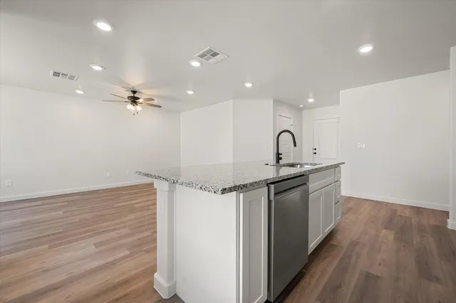 a kitchen with a sink cabinets and wooden floor