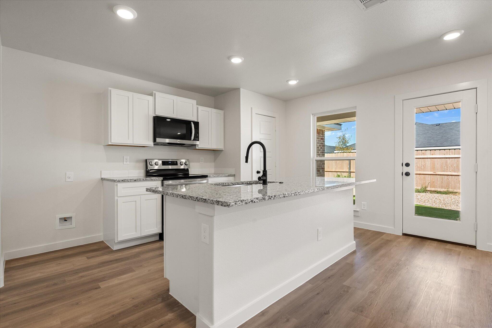8316 24th Street Lubbock, TX 79407 - Photo 6 of 22 a kitchen with stainless steel appliances granite countertop a stove a sink and a microwave