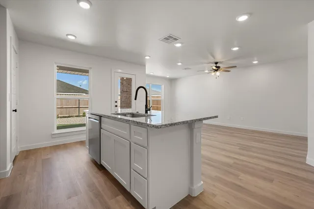 a kitchen with kitchen island a sink and wooden floor