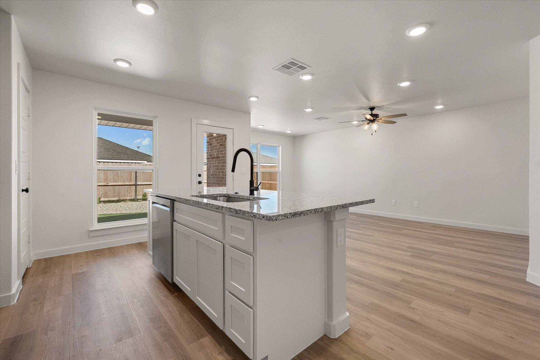 8316 24th Street Lubbock, TX 79407 - Photo 9 of 22 a kitchen with kitchen island a sink and wooden floor