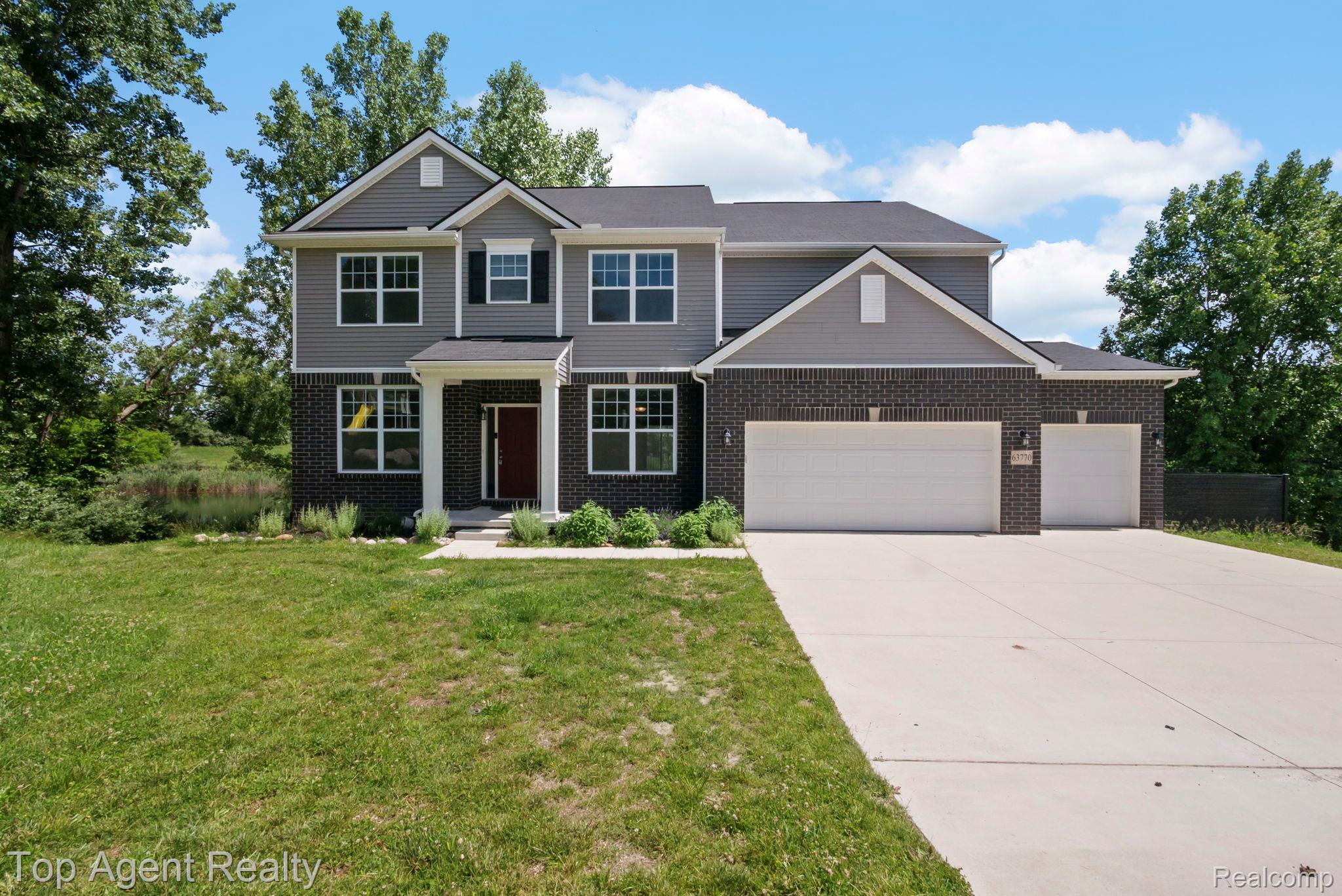 63770 Dequindre Road Washington, MI 48095 - Photo 1 of 61 Contemporary two-story residence featuring a gray siding and dark brick exterior