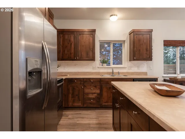 a kitchen with kitchen island granite countertop a sink stove and refrigerator