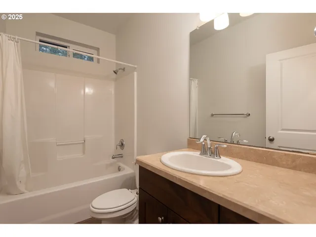 a bathroom with a sink a toilet a mirror and shower