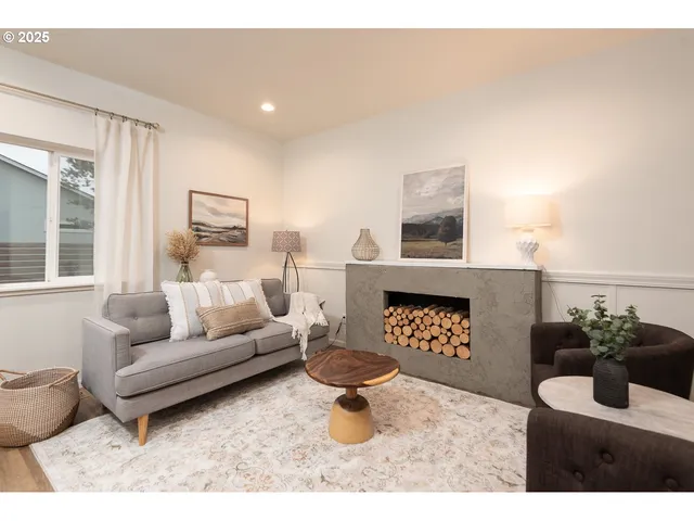 a living room with furniture a rug and wall paintings