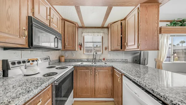 a kitchen with stainless steel appliances granite countertop a sink stove and cabinets