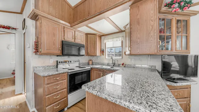 a kitchen with granite countertop a stove and a wooden floors