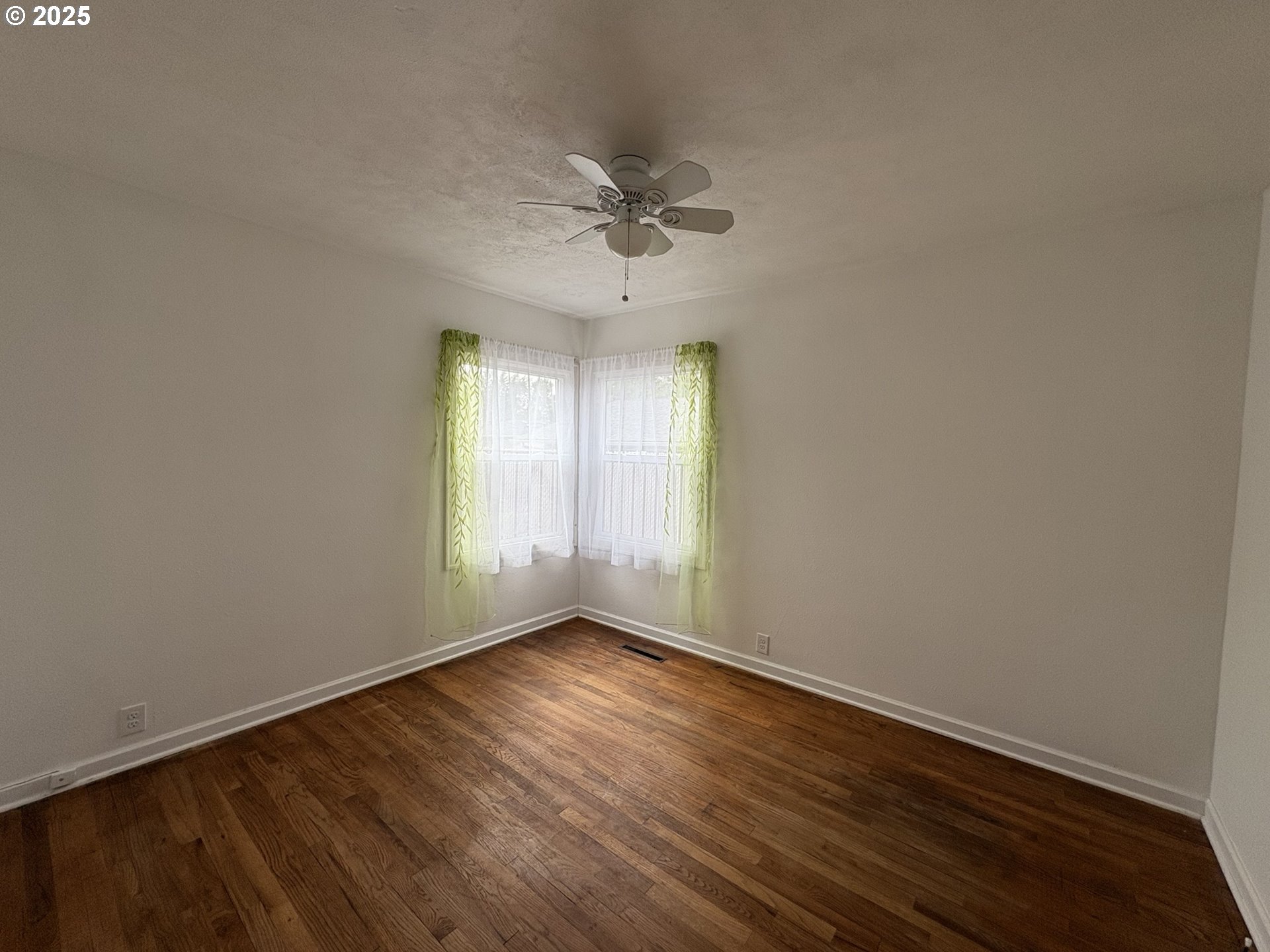 1510 Northwest Broadway Street Albany, OR 97321 - Photo 22 of 32 an empty room with wooden floor fan and windows